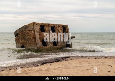 Abandoned buildings on the seashore in the water. War ruins decomposing in the Baltic sea. Former fort bunkers in Liepaja, Latvia. Stock Photo