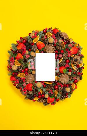 Colorful wreath in the yellow background. Garland decorated with fruit and berries on the bright surface. Stock Photo