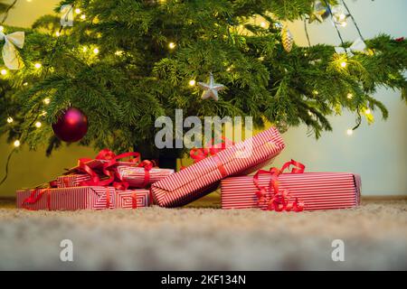 Wrapped gifts under the christmas tree. Presents under the decorated pine tree. Stock Photo