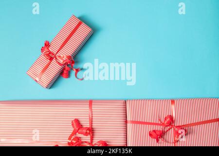 Wrapped gifts on the blue background. Presents on top of the bright backdrop. Stock Photo