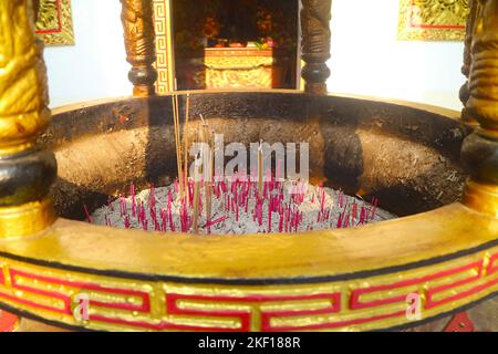 Group of Incenses Burning in a Golden Burner in front of Chinese Buddhist Shrine Stock Photo