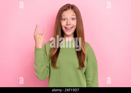 Photo of cool funky school girl dressed green sweatshirt showing hard rock sign isolated pink color background Stock Photo