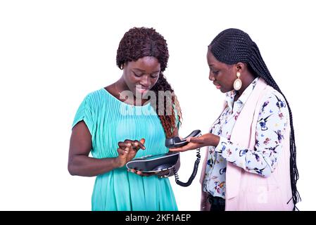 portrait of two beautiful young serious women using a mobile phone together. Stock Photo