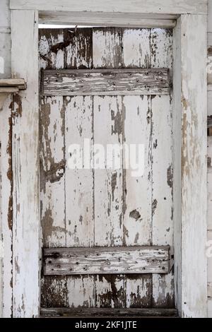 Very old door with extreme peeling white paint Stock Photo
