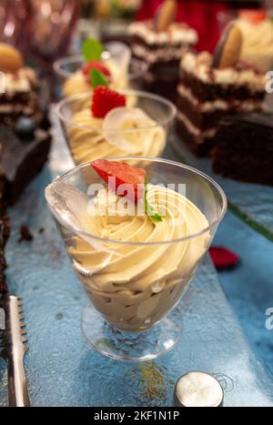 cream dessert with strawberries in a transparent plastic cup close-up. Stock Photo