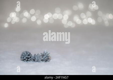 christmas postcard with silver pine cones and abstract bokeh lights in the background with space copy Stock Photo