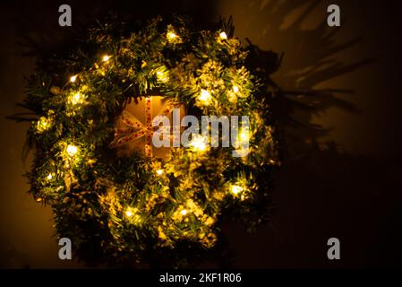 Gift box in Christmas ring or wreath with glowing garland Stock Photo