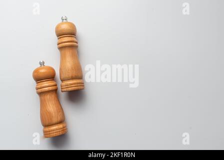 salt and pepper wooden shakers, grinders on a white table with white background Stock Photo