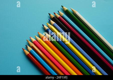 a set of colored pencils on a blue table. Stock Photo