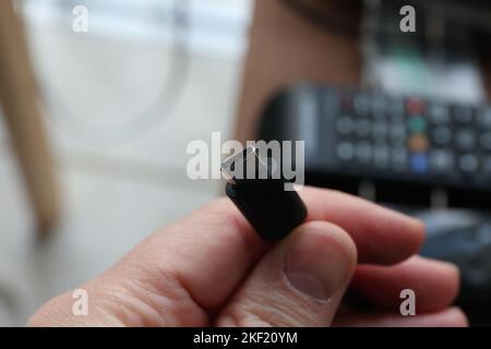 A macro portrait of someone holding a usb c cable in his hands. Ready to charge a phone or other device. Or connect with a computer to send or receive Stock Photo