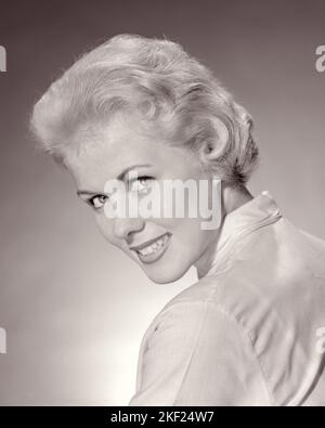 1950s PORTRAIT PRETTY TEEN GIRL SMILING WITH SHORT BLONDE HAIR LOOKING AT CAMERA OVER HER SHOULDER - g224 HAR001 HARS CONFIDENCE B&W EYE CONTACT PRETTY HAPPINESS HEAD AND SHOULDERS CHEERFUL JOYFUL STYLISH TEENAGED YOUNG ADULT WOMAN BLACK AND WHITE CAUCASIAN ETHNICITY HAR001 OLD FASHIONED