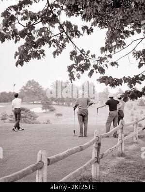 1960s 1970s BACK VIEW OF GROUP OF MEN AT TEE OFF SPOT WITH ONE MAN JUST COMPLETING HIS SWING - g7131 HAR001 HARS TEE COPY SPACE FRIENDSHIP PHYSICAL FITNESS PERSONS MALES JUST GOLFING SPOT MIDDLE-AGED B&W CLUBS MIDDLE-AGED MAN GOALS ACTIVITY GOLFERS HIS LEISURE STRENGTH RECREATION FAIRWAY REAR VIEW FROM BEHIND ESCAPE FLEXIBILITY FRIENDLY LINKS MUSCLES COMPLETING FATHERS AND SONS BACK VIEW COOPERATION MID-ADULT MID-ADULT MAN TOGETHERNESS YOUNG ADULT MAN YOUNG ADULTS BLACK AND WHITE CAUCASIAN ETHNICITY GOLF COURSE HAR001 OLD FASHIONED Stock Photo