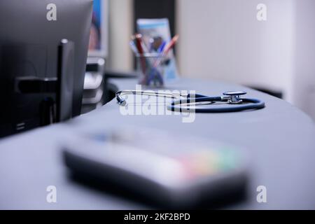 Unused stethoscope to check heart of patients on table. Medical equipment to review vital signs without doctors using it. Hospital tools for routine medical checkups on desk in reception area of clinic. Stock Photo