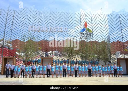 Kazakhstan pavilion staff team in uniform lined up in front of it for the memorable photo of their participation in the Great Exhibition global event. Stock Photo