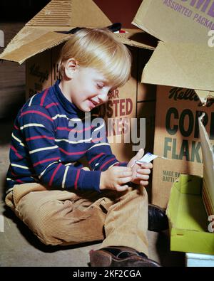 1960s LITTLE BLONDE BOY SITTING ON FLOOR BESIDE CARDBOARD BOXES PLAYING WITH BOOK OF MATCHES - kj4227 HAR001 HARS CARDBOARD DANGEROUS DISCOVERY MISCHIEF PROTECTION EXCITEMENT POWERFUL RISKY HAZARDOUS MATCHES MENTAL HEALTH PERIL UNSAFE BESIDE CURIOUS FIRE HAZARD JEOPARDY BEHAVIOR JUVENILES CAUCASIAN ETHNICITY CURIOSITY HAR001 MENTAL ILLNESS OLD FASHIONED Stock Photo