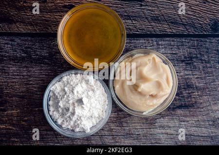 Classic Southern Gravy in Small Glass Bowls on a Wood Table: Flour, bacon fat, and chicken stock for Southern style gravy Stock Photo