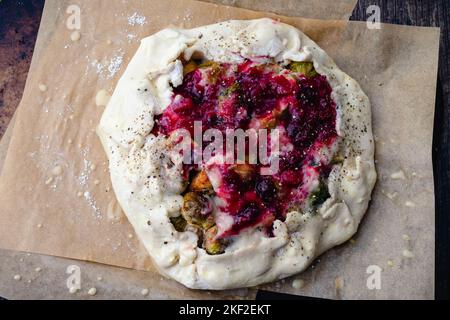 Making a Thanksgiving Leftovers Galette : Pastry dough rolled out and topped with savory and sweet filling Stock Photo