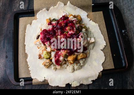 Making a Thanksgiving Leftovers Galette : Pastry dough rolled out and topped with savory and sweet filling Stock Photo