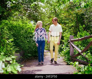 1960s 1970s YOUNG COUPLE HOLDING HANDS SMILING WALKING ALONG COUNTRY PATH IN PARK SUMMERTIME - ks5827 HAR001 HARS NOSTALGIC PAIR ROMANCE COLOR RELATIONSHIP OLD TIME NOSTALGIA OLD FASHION 1 JUVENILE STYLE BLOND PLEASED JOY LIFESTYLE FEMALES HEALTHINESS COPY SPACE FRIENDSHIP FULL-LENGTH PERSONS MALES TEENAGE GIRL TEENAGE BOY SUMMERTIME DATING PATH HAPPINESS CHEERFUL DISCOVERY ALONG RECREATION HOLDING HANDS TO ATTRACTION RELATIONSHIPS SMILES CONNECTION COURTSHIP JOYFUL STYLISH TEENAGED POSSIBILITY COOPERATION JUVENILES SOCIAL ACTIVITY TOGETHERNESS CAUCASIAN ETHNICITY COURTING HAR001 OLD FASHIONED Stock Photo