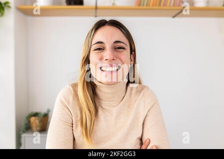 POV video call screen of young adult woman smiling at camera on virtual meeting Stock Photo