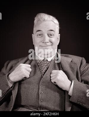 1940s MATURE MAN WEARING THREE PIECE SUIT THUMBS TUCKED IN VEST WITH FACIAL EXPRESSION OF JOY PLEASURE PRIDE SATISFACTION - s8968 HAR001 HARS JOY LIFESTYLE SATISFACTION ELDER PROUD GRANDPARENT STUDIO SHOT HEALTHINESS HOME LIFE COPY SPACE FRIENDSHIP HALF-LENGTH PERSONS MALES RETIREMENT CONFIDENCE SENIOR MAN VEST SENIOR ADULT EXPRESSIONS B&W THUMBS EYE CONTACT RETIREE SUIT AND TIE HAPPINESS OLD AGE OLDSTERS CHEERFUL OLDSTER DISCOVERY EXCITEMENT PRIDE PLEASURE OCCUPATIONS SMILES ELDERS THREE PIECE SUIT JOYFUL STYLISH TUCKED ELDERLY MAN BLACK AND WHITE CAUCASIAN ETHNICITY HAR001 OLD FASHIONED Stock Photo