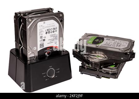 A stack of three hard drives next to a hard drive caddy Stock Photo