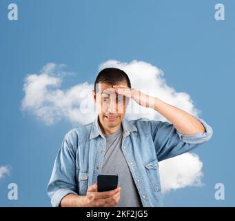 Man texting using smartphone over isolated cloud background stressed with hand on head, shocked with shame and surprise face, angry and frustrated. Fe Stock Photo