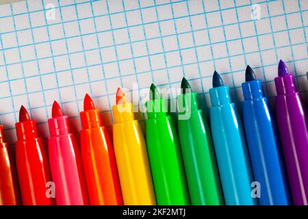 Image of opened multicolored markers on notepad Stock Photo