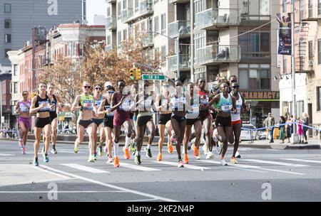 2022 TCS New York City Marathon runners cruise up 4th Avenue through Park Slope Brooklyn during the first leg of the race. Sharon Lokedi from Kenya (right side with red top)eventually won the race. Stock Photo