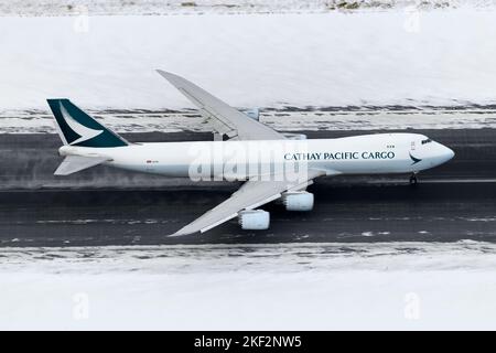 Cathay Pacific Cargo Boeing 747-8F aircraft departing Anchorage Airport after a snow fall. Airplane of Cathay Pacific Cargo 747 freighter taking off. Stock Photo