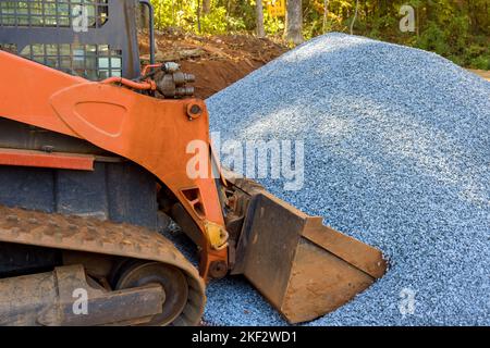 Wheel loader excavator for unloading crushed stone during repair road works in construction site Stock Photo