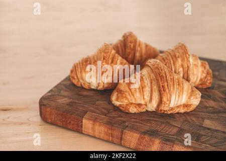 Croissants fresh baked pastries from french bakery. 4 viennoiseries on wooden board. Breakfast food from France baking culture. Flaky warm croissant Stock Photo