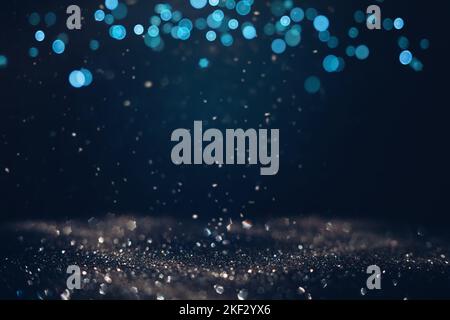Glowing in the dark defocused glitter texture with blue bokeh lights and snow. Christmas and winter holidays background Stock Photo