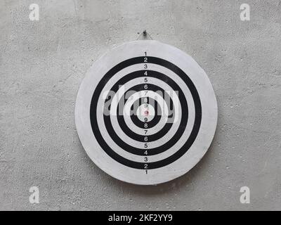 black white Darts board flippy knife game on the cement wall Stock Photo