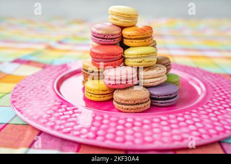 Macarons tower dessert at home. Cute retro vintage pink plate on checkered tablecloth easter decoration home kitchen. pastel color macaron of Stock Photo