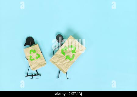 Environment friendly, sustainable and ecological shopping or consumerism concept. Couple stick figure holding paper shopping bag with recycling symbol Stock Photo