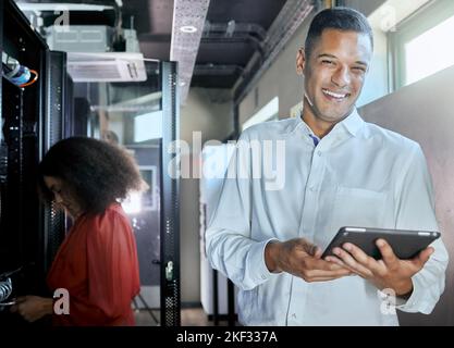 Server room, employees and man with tablet working on internet or web connection. Portrait, smile and maintenance technician with coworker programming Stock Photo