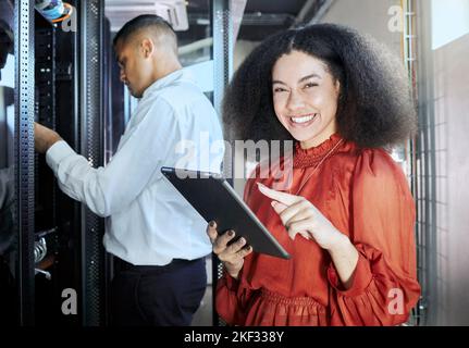 Tablet, tech and team working in a server room to repair a technical networking box in the office. Technology, collaboration and portrait of engineers Stock Photo