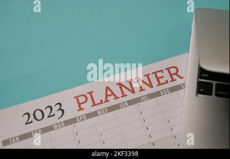 2023 Planner Calendar with computer laptop. Top view, copy space. Stock Photo