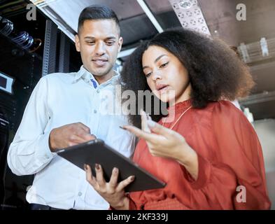 Tablet, woman and man check cyber security, connect server internet or coding information. IT specialist, female programmer and male coder talk with Stock Photo