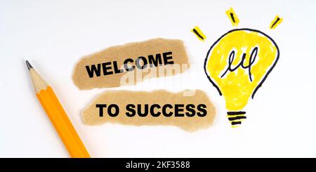 Business and finance concept. A lamp is drawn on a white sheet, there is a pencil and scraps of paper on which it is written - WELCOME TO SUCCESS Stock Photo