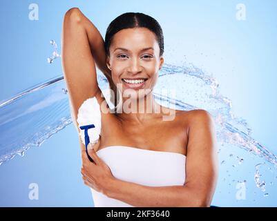 Armpit shaving, black woman and hair removal, water splash or skincare, clean body and wellness, personal hygiene and beauty cosmetics on blue Stock Photo