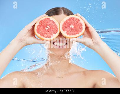 Grapefruit, portrait and woman in studio face, water splash and wellness promotion for skincare, detox and shower. Beauty model cover eyes with Stock Photo