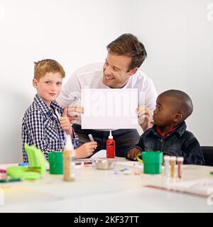 Giving him a voice. a volunteer holding up a blank sign while working with little children. Stock Photo