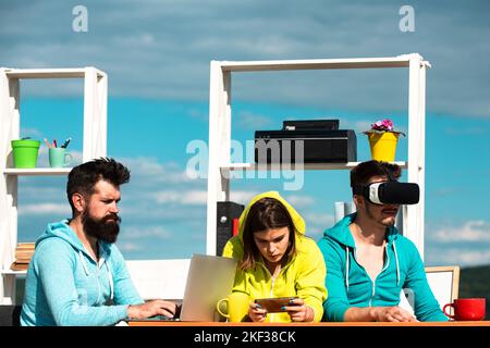 Business team using virtual reality headset and digital gadgets outdoors office. Digital accessories on meeting. Developers meeting with virtual Stock Photo