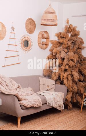 Stylish modern sofa in the home interior. Christmas tree made of dried flowers Stock Photo