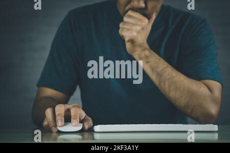 Asian freelance man having stressful depression sad time while working on laptop keyboard mouse at home. Depression man sad serios working from home. Stock Photo