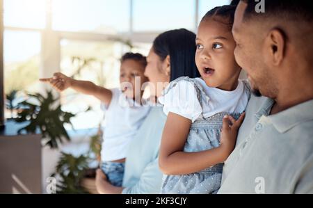 Bonding, love and parents with children in the living room of their house talking with a smile. Wow, freedom and father speaking to his girl with Stock Photo