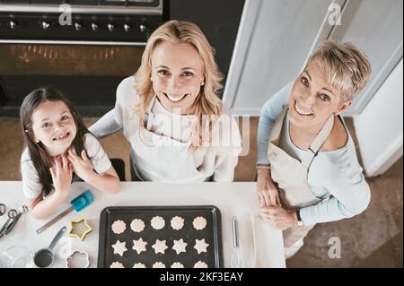 .Family, cooking and cookies portrait top view with happy smile together helping in home kitchen. Learning, grandma and mother with child busy with Stock Photo