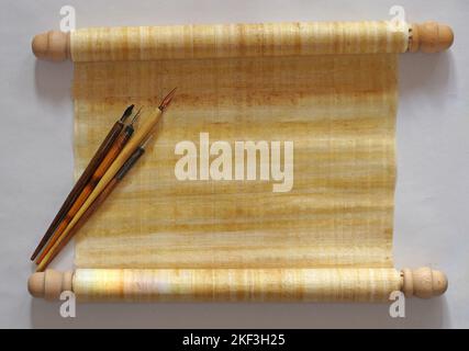 One papyrus scroll with four old fashioned nib pens with holder on top of it. Top table view. With space for your own text Stock Photo